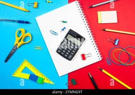 Various colorful markers and stationery items are scattered on a red / blue surface, showcasing vibrant tools for creativity and organization. Stock Photo