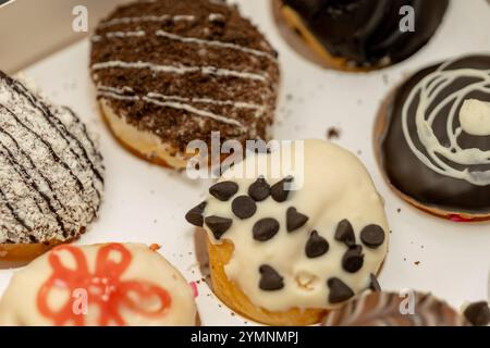 Assorted mini donuts with colorful toppings and icing in a white box. Sweet treat perfection! Stock Photo