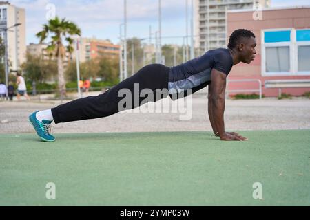 Young black man doing push-ups outdoors in a calisthenics workout Stock Photo