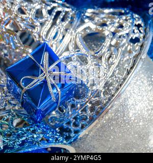 Silver bells and blue gift box. Decorations for the New Year and Christmas. A place for congratulations. Stock Photo
