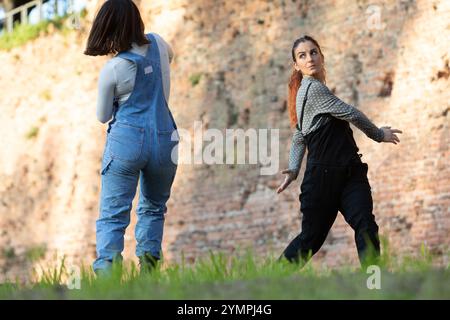 Pair of dancers practicing a modern dance choreography outdoors in front of an old brick wall Stock Photo