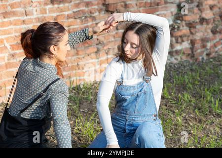Two dancers practicing a modern dance choreography outdoors in front of a brick wall Stock Photo