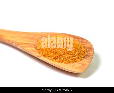 Brown cane sugar on a wooden spoon against a white background Stock Photo