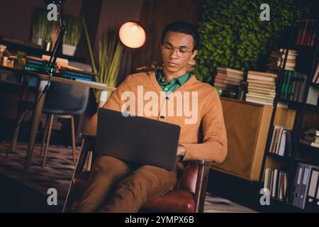 Young student working on laptop indoors focusing on study and freelance projects Stock Photo