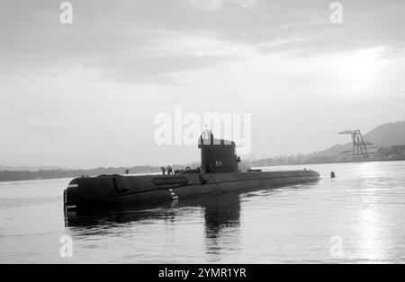 Silhouetted port bow view of the nuclear-powered attack submarine ex-USS Nautilus (SSN 571) as it is towed from the pier at US Naval Station Rodman.  The Nautilus was en route to its original home port at Naval Submarine Base,  New London, Connecticut, where it will remain as a memorial at the Submarine Force Library and Museum. Stock Photo