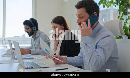 Professional team businessmen and businesswoman solving business issues sales answer mobile phone group diverse workers talking customer service use Stock Photo
