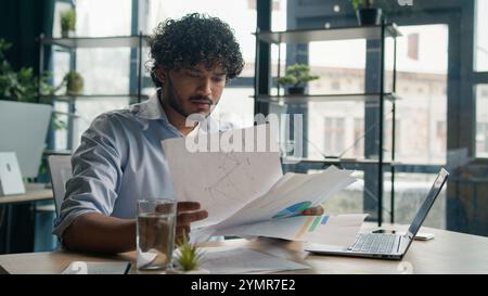 Focused businessman business person accountant office worker writing ideas in notebook paperwork Arabian Indian student write notes data information e Stock Photo