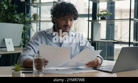 Focused businessman business person accountant office worker writing ideas in notebook paperwork Arabian Indian student write notes data information e Stock Photo
