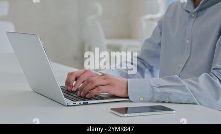 Moving shot Arabian Indian businessman ethnic smiling man working laptop male business employer programmer coding computer program software typing Stock Photo