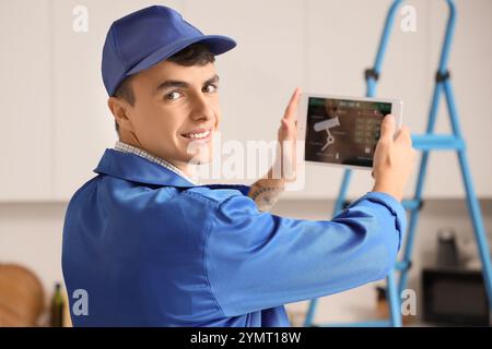 Male worker with tablet installing alarm system in house Stock Photo