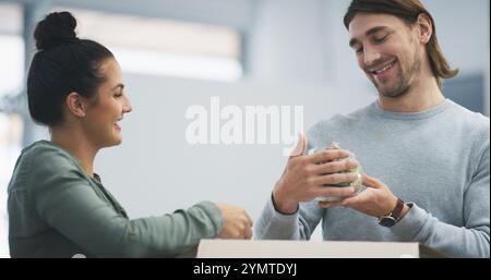 Home, couple and happy with box for unpacking, preparation and bonding together in healthy marriage. Dating people, woman and man with smile in new Stock Photo