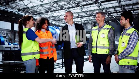 Power Plant Engineers And Diverse Group Of Workers Shaking Hands Stock Photo