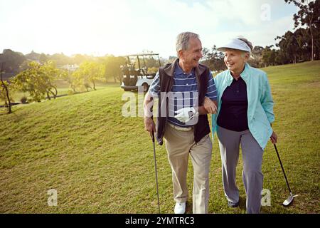 Golf, hobby and walking with happy old couple outdoor on course together for leisure. Grass, love and mockup space with smile of senior people playing Stock Photo