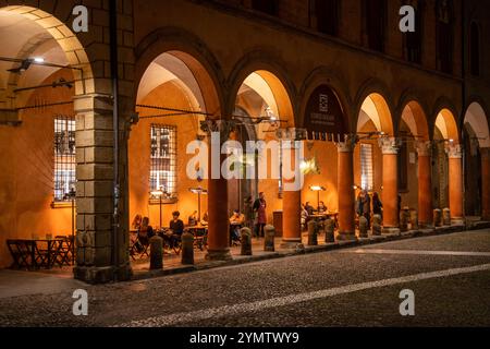 People relaxing and having dinner in Piazza Santo Stefano. A well-known and picturesque square in Bologna with the Basilica di Santo Stefano. Italy Stock Photo