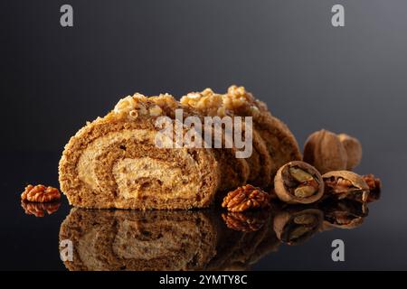 Dessert with walnuts on a black reflective background. Cake with brown sugar, walnuts, and cream. Copy space. Stock Photo