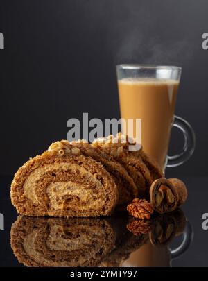Dessert with walnuts and coffee latte on a black reflective background. Cake with brown sugar, walnuts, and cream. Copy space. Stock Photo