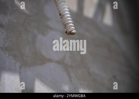 AC drain pipe dripping water on a wall Stock Photo - Alamy