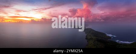 Dramatic sunset over St Kitts, Christophe Harbor colorful sun rays painting the clouds pink, red and purple as the sun sets over Nevis peak Stock Photo