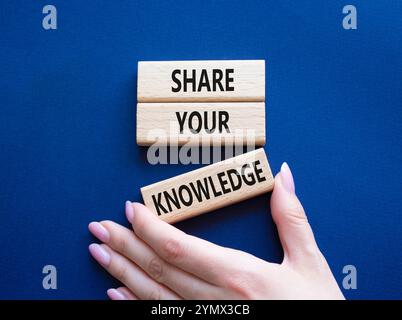 Share your knowledge symbol. Concept word Share your knowledge on wooden blocks. Businessman hand. Beautiful deep blue background. Business and Share Stock Photo