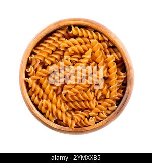 Chickpea spiral pasta, gluten free noodles in a wooden bowl, isolated from above. Small fusilli, a pasta variety with helical or corkscrew shape. Stock Photo