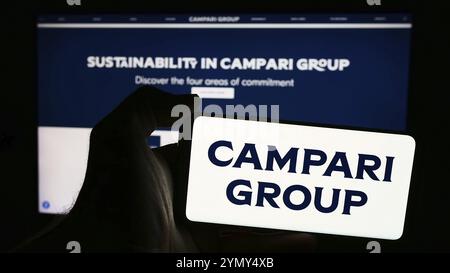 Stuttgart, Germany, 06-01-2024: Person holding smartphone with logo of Italian spirits company Davide Campari-Milano N.V. in front of website. Focus o Stock Photo