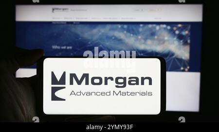 Stuttgart, Germany, 03-25-2024: Person holding cellphone with logo of British company Morgan Advanced Materials plc in front of business webpage. Focu Stock Photo