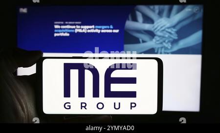 Stuttgart, Germany, 03-25-2024: Person holding cellphone with logo of British vending machine company ME Group International plc in front of webpage. Stock Photo