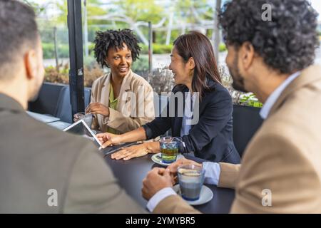Business people using digital tablet during a meeting in a modern cafeteria Stock Photo