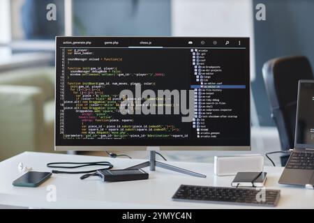 Workspace with multiple electronics, including computer monitors, keyboards, and other devices used for developing software and managing code displayi Stock Photo