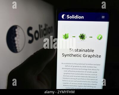 Stuttgart, Germany, 07-16-2024: Person holding cellphone with webpage of US battery materials company Solidion Technology Inc. in front of logo. Focus Stock Photo