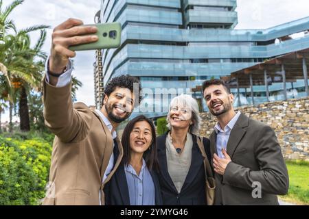 Diverse group of business people taking selfie outside a financial building in a tropical city Stock Photo