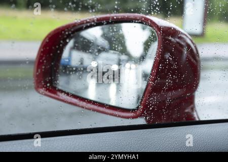 Wet road in the wing mirror of a car Stock Photo