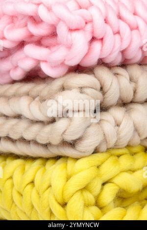 Close-Up of Chunky Knit Wool Blankets in Soft Pink, Beige, and Yellow – Cozy Handcrafted Textures for Home Decor, Knitting Projects, and Warm Interior Stock Photo