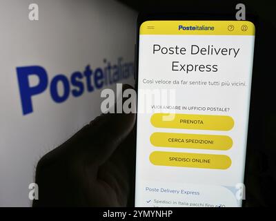 Stuttgart, Germany, 06-01-2024: Person holding smartphone with webpage of Italian postal services company Poste Italiane S.p.A. with logo. Focus on ce Stock Photo