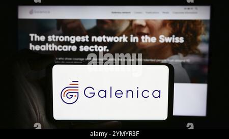 Stuttgart, Germany, 05-31-2024: Person holding cellphone with logo of Swiss pharmaceuticals company Galenica AG in front of business webpage. Focus on Stock Photo