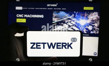 Stuttgart, Germany, 07-12-2024: Person holding cellphone with logo of Indian company Zetwerk Manufacturing Businesses Pvt. Ltd. in front of webpage. F Stock Photo