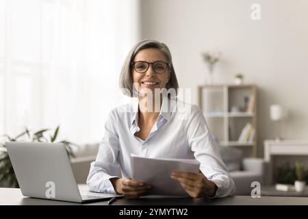 Happy successful business manager woman in glasses doing paperwork Stock Photo