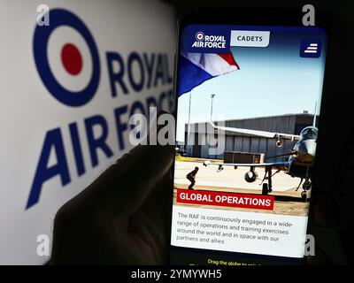 Stuttgart, Germany, 03-25-2024: Person holding smartphone with webpage of United Kingdom air and space force Royal Air Force (RAF) with logo. Focus on Stock Photo