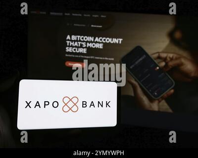 Stuttgart, Germany, 07-03-2024: Person holding smartphone with logo of crypto banking company Xapo Holdings Limited in front of website. Focus on phon Stock Photo