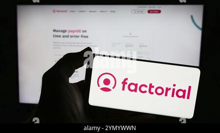 Stuttgart, Germany, 03-28-2024: Person holding smartphone with logo of Spanish company Everyday Software S.L. (Factorial HR) in front of website. Focu Stock Photo