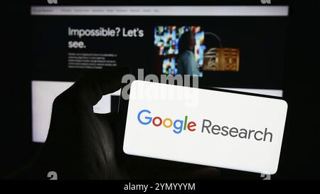 Stuttgart, Germany, 04-02-2024: Person holding smartphone with logo of US technology company Google Research in front of website. Focus on phone displ Stock Photo