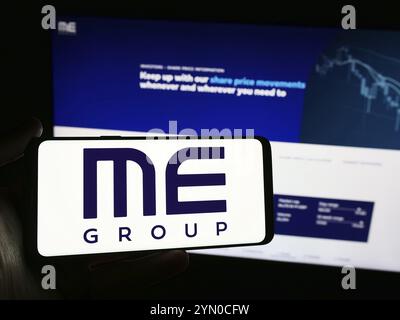 Stuttgart, Germany, 03-25-2024: Person holding smartphone with logo of British vending machine company ME Group International plc in front of website. Stock Photo