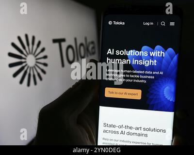 Stuttgart, Germany, 03-25-2024: Person holding cellphone with webpage of artificial intelligence company Toloka AI BV in front of logo. Focus on cente Stock Photo