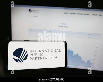 Stuttgart, Germany, 03-20-2024: Person holding mobile phone with logo of British company International Public Partnerships Limited in front of web pag Stock Photo