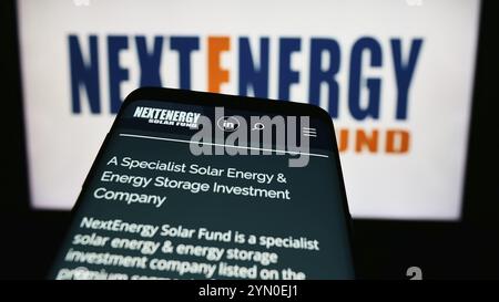 Stuttgart, Germany, 03-25-2024: Mobile phone with webpage of investment company NextEnergy Solar Fund Limited in front of business logo. Focus on top- Stock Photo