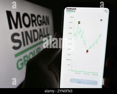 Stuttgart, Germany, 03-25-2024: Person holding cellphone with website of British construction company Morgan Sindall Group plc in front of logo. Focus Stock Photo