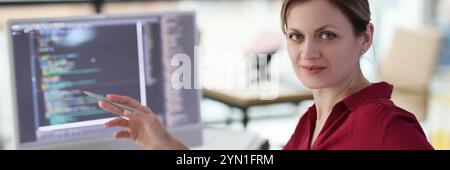 Woman shows with pen on complex code developing software Stock Photo