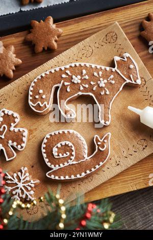 Decorating animal and star shaped homemade gingerbread Christmas cookies with white icing Stock Photo