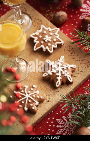 Star shaped gingerbread Christmas cookies with two glasses  of Eiecognac on a wooden table with spruce tree branches Stock Photo