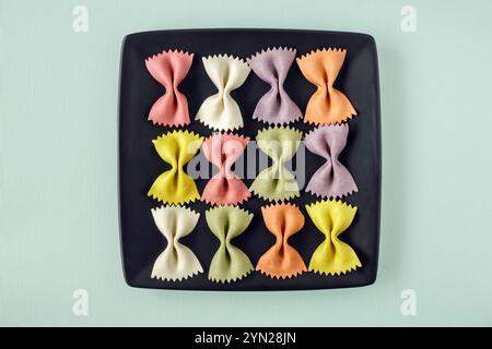 Large colourful Farfalle pasta arranged on black square plate Stock Photo